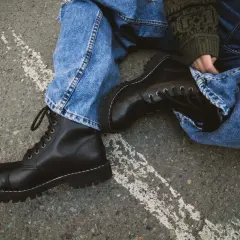 Czarne, sznurowane buty na grubej podeszwie, jeansy i sweter w zielone wzory – idealny zestaw w rock style.