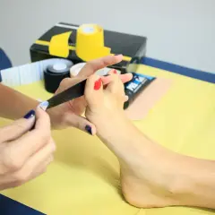 Zastosowanie taśmy kinezjotapingowej na palce stopy, by złagodzić ból spowodowany za ciasne buty.