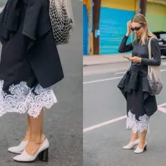 Elegancka koronkowa spódnica stylizacje z czarną marynarką i siatkową torbą. Kobieta w okularach przeciwsłonecznych i szarej bluzce z długim rękawem.