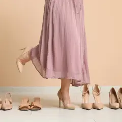 Wybieram idealne sandały do sukienki. Kilka par eleganckich butów na podłodze.