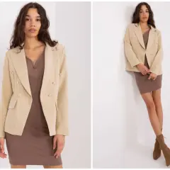 Elegancka sukienka i dwurzędowa marynarka tworzą stylową stylizację. Modelka prezentuje zestaw w beżowo-brązowej kolorystyce.