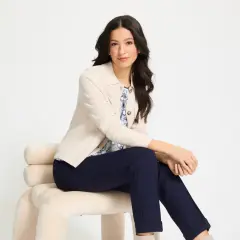 Kobieta w beżowej marynarce i granatowych spodniach, prezentująca eleganckie stylizacje.
