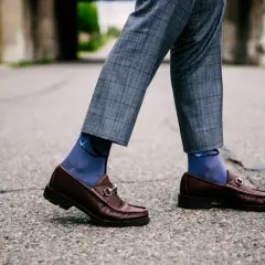 Eleganckie skarpetki do mokasynów w kolorze granatowym z motywem ptaków, idealnie komponują się z szarymi spodniami w kratę.