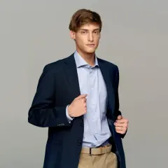 Elegancki mężczyzna w granatowej marynarce i błękitnej koszuli. Idealne męskie stylizacje na imprezę.