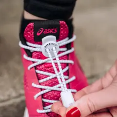 Różowe buty Asics z białymi sznurówkami wstążkami, które ułatwiają zakładanie.