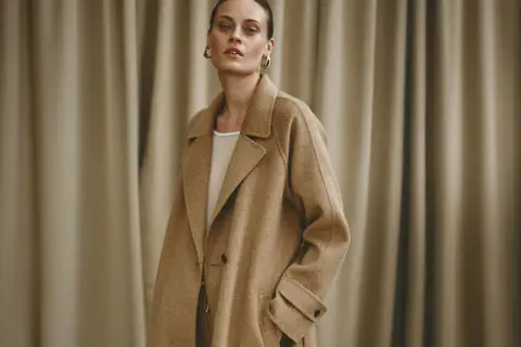 Elegancka kobieta w beżowym płaszczu, prezentująca stylowe brazowy plaszcz stylizacje.