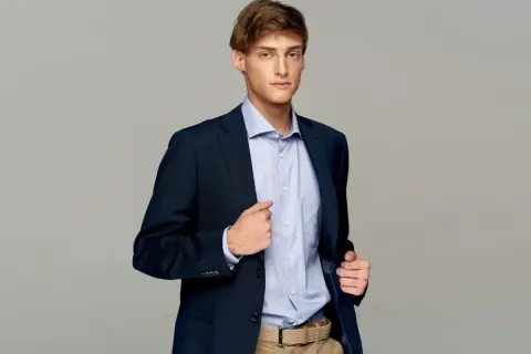 Elegancki mężczyzna w granatowej marynarce i błękitnej koszuli. Idealne męskie stylizacje na imprezę.