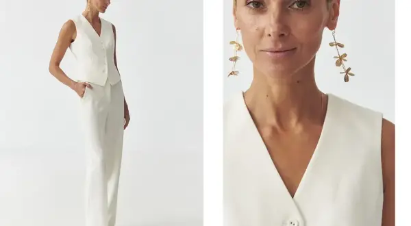 Elegancka kamizelka damska w kremowym kolorze, idealna do stylizacji z szerokimi spodniami. Długie, złote kolczyki dodają szyku.