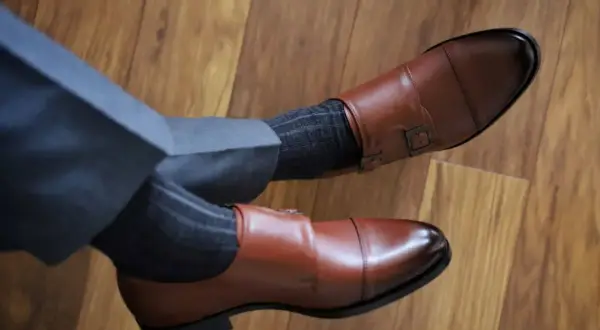Eleganckie brązowe buty monk strap i grafitowe skarpetki w prążki. Idealne połączenie, gdy zastanawiasz się, jakie skarpetki do brązowych butów pasują.
