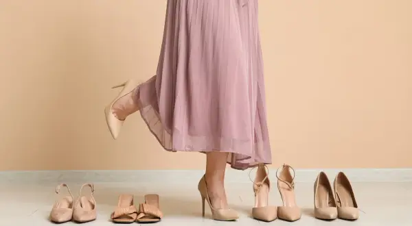 Wybieram idealne sandały do sukienki. Kilka par eleganckich butów na podłodze.