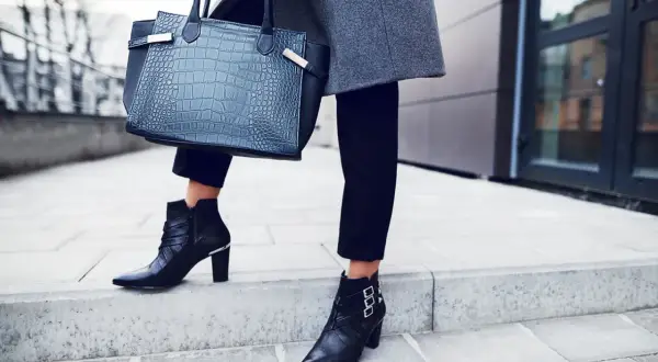 Eleganckie stylizacje z botkami na obcasie: czarne, skórzane botki z klamrami i metalowymi detalami, do tego szara marynarka i torebka z fakturą skóry krokodyla.