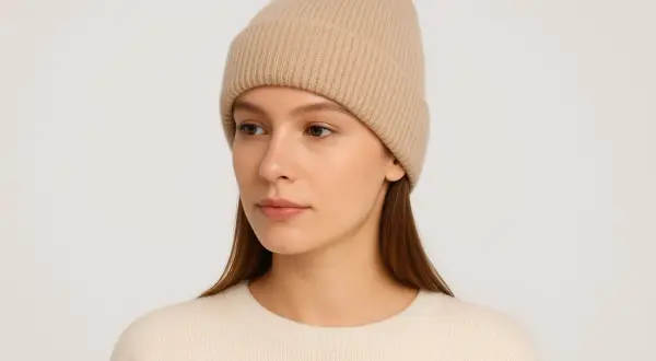 Modelka w beżowej czapce beanie, prezentująca różne rodzaje czapek.