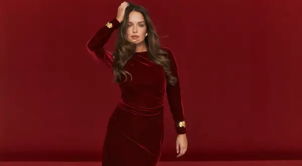 Elegancka kobieta w czerwonej welurowej sukience z złotymi zdobieniami. Idealne buty do welurowej sukienki podkreślą jej styl.