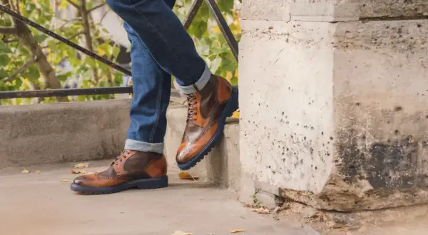 Męskie buty w stylu retro, sznurowane, brązowe, z granatową podeszwą, idealne do jeansów.