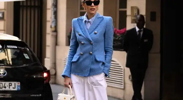 Elegancka kobieta w niebieskiej marynarce i białych spodniach. Inspiracja, jak się ubierać po 40. Stylowo i z klasą.