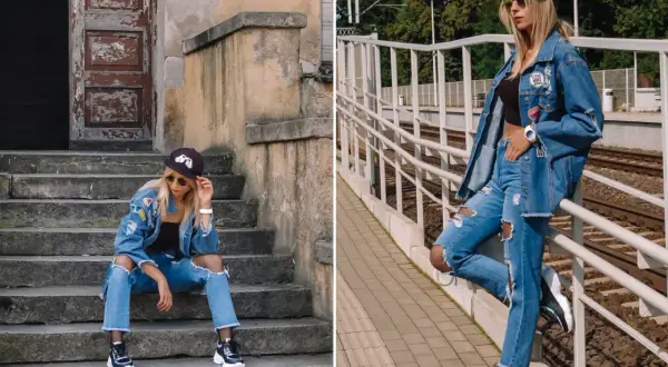 Stylowa kobieta w jeansach boyfriend i kurtce denim, z naszywkami i przetarciami, na tle schodów i torów kolejowych.
