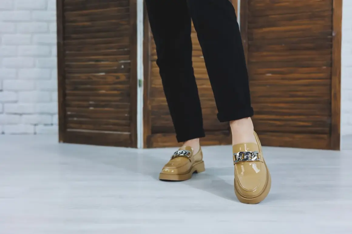 Eleganckie, lakierowane loafersy do sukienki z ozdobnym łańcuchem. Idealne do stylizacji na co dzień i na specjalne okazje.