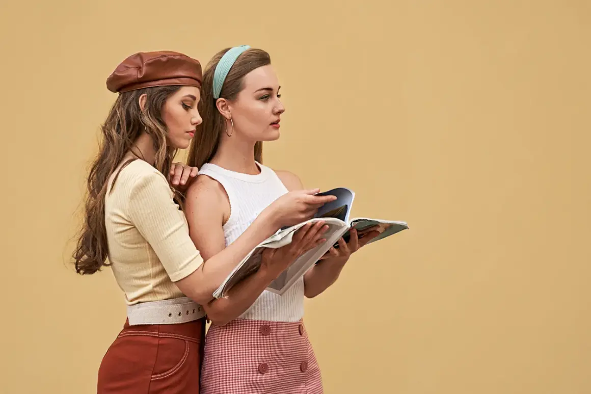Dwie kobiety w stylizacjach z lat 60. moda damska, jedna w brązowym beretku, druga czyta magazyn.