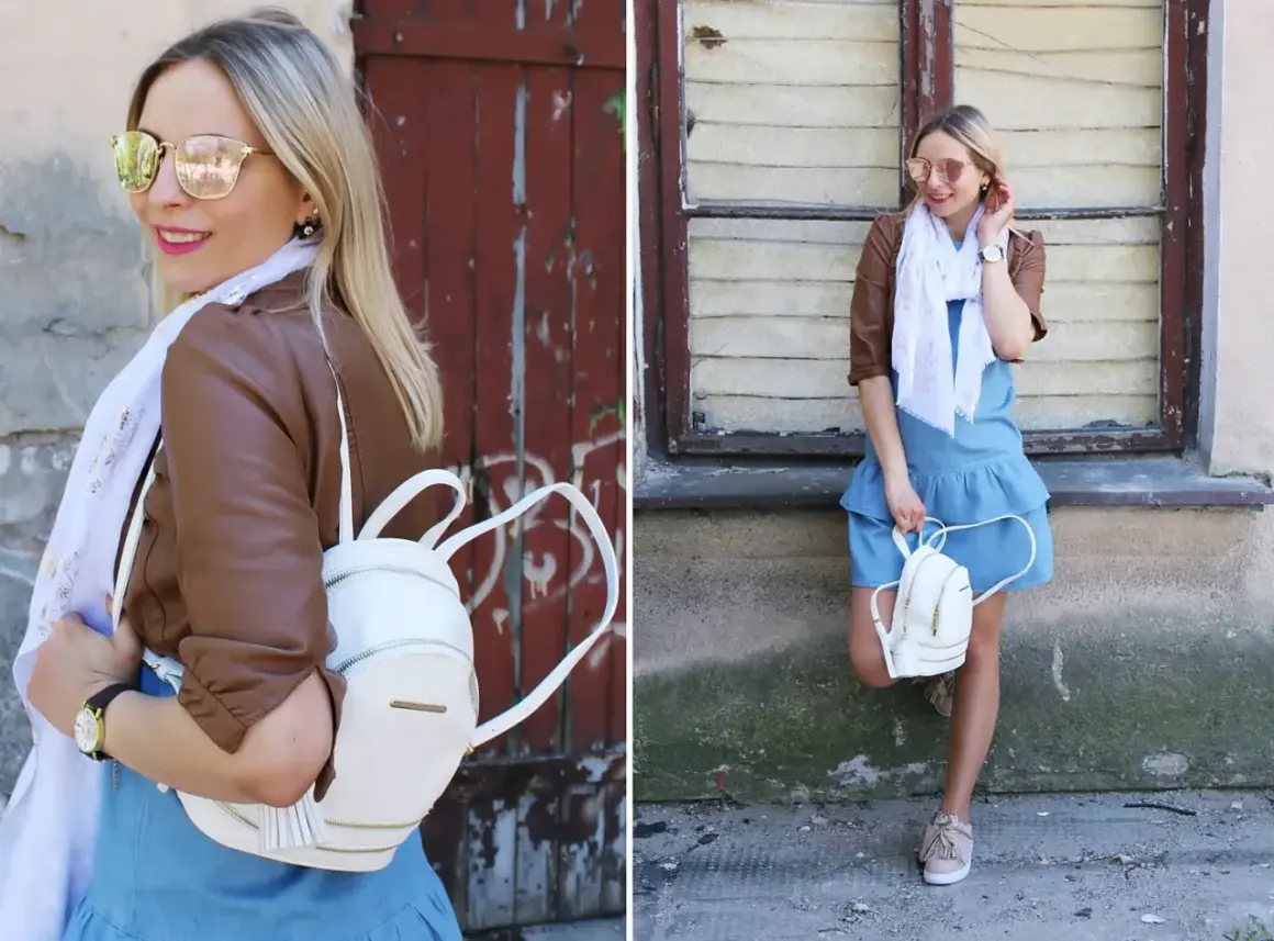 Kobieca stylizacja: jeansowa sukienka, brązowa ramoneska, biały plecaczek i beżowe sneakersy. Idealne buty do jeansowej sukienki na co dzień.