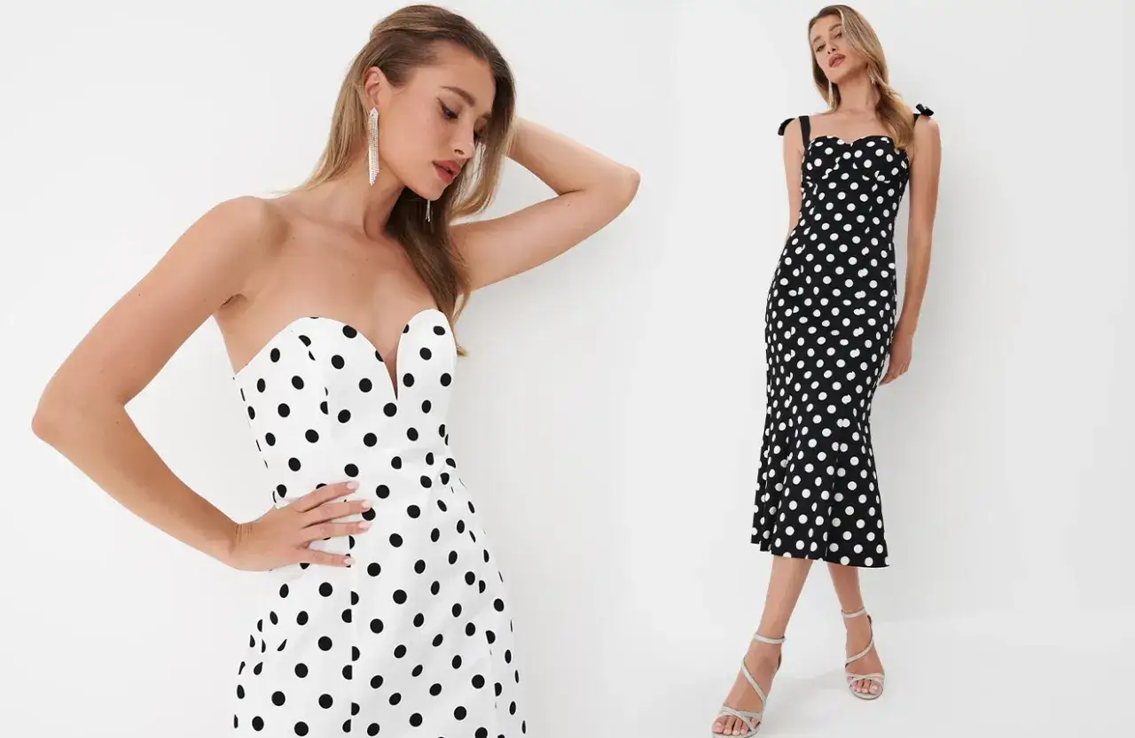 Dwie kobiety w sukienkach w grochy, stylizowanych na lata 50. moda. Jedna w białej bez ramiączek, druga w czarnej z ramiączkami.