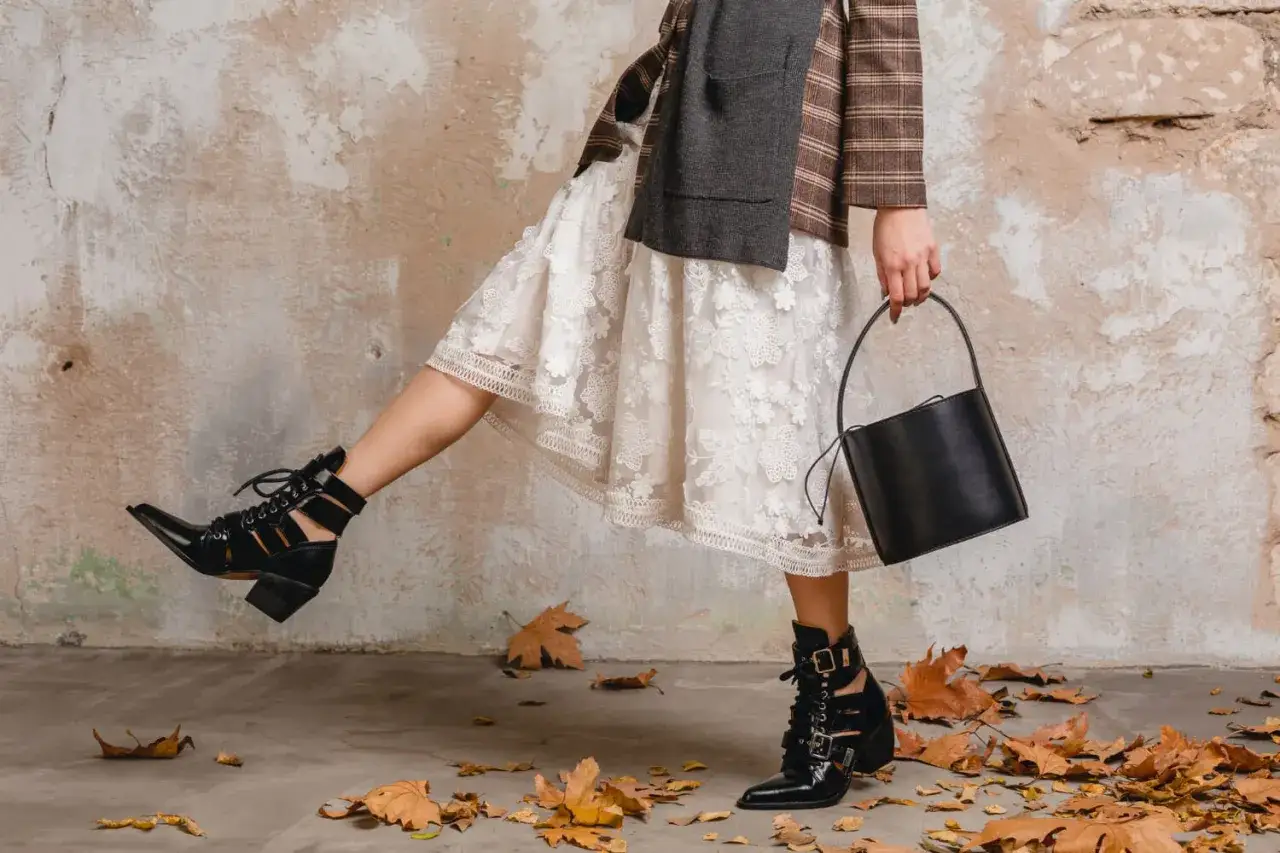 Eleganckie botki do spódnicy stylizacje. Czarna, lakierowana skóra, koronka i jesienne liście tworzą modny look.