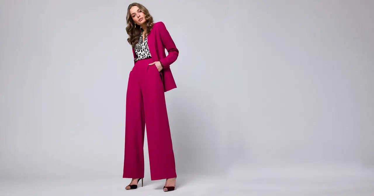 Elegancka stylizacja na chrzciny ze spodniami: fuksjowy garnitur, bluzka w panterkę i czarne szpilki.