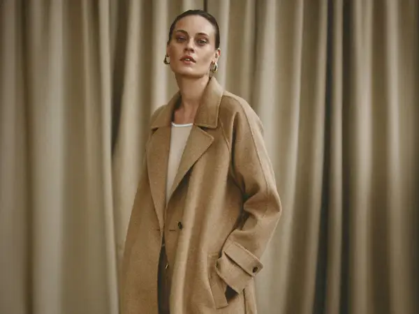 Elegancka kobieta w beżowym płaszczu, prezentująca stylowe brazowy plaszcz stylizacje.