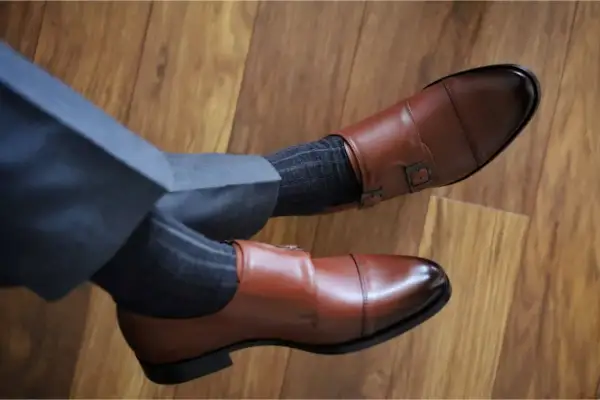 Eleganckie brązowe buty monk strap i grafitowe skarpetki w prążki. Idealne połączenie, gdy zastanawiasz się, jakie skarpetki do brązowych butów pasują.