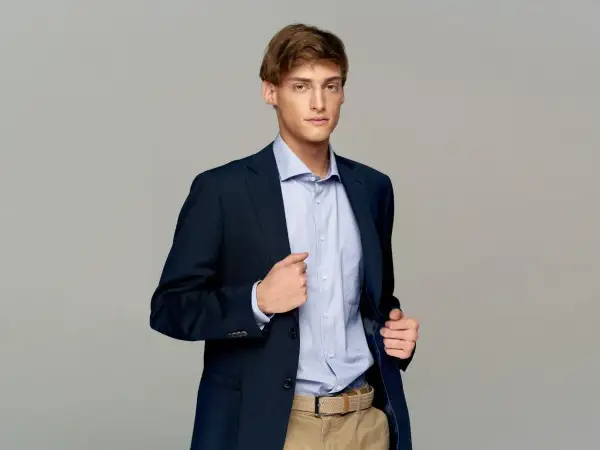 Elegancki mężczyzna w granatowej marynarce i błękitnej koszuli. Idealne męskie stylizacje na imprezę.